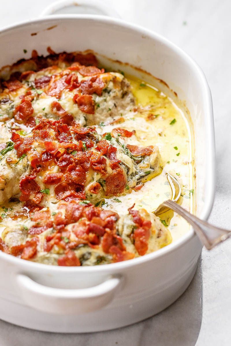 Cazuela de pollo Alfredo con espinacas y tocino, rica, cremosa y tan deliciosa que te volverás loco por los sabores de esta cena de pollo fácil.Crédito de la foto: © Eatwell101.com'll go crazy for the flavors of this easy chicken dinner.