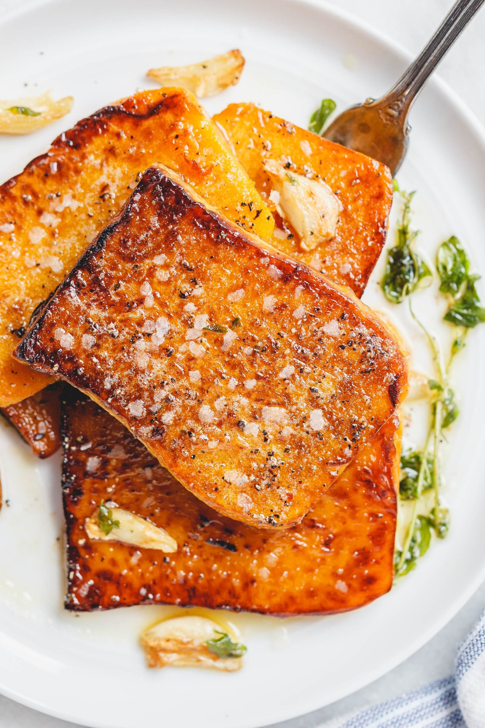 Garlic Butter Butternut Squash Steaks - Melt-in-your-mouth tender and packed with flavor! A super easy and delicious side dish for the holidays.