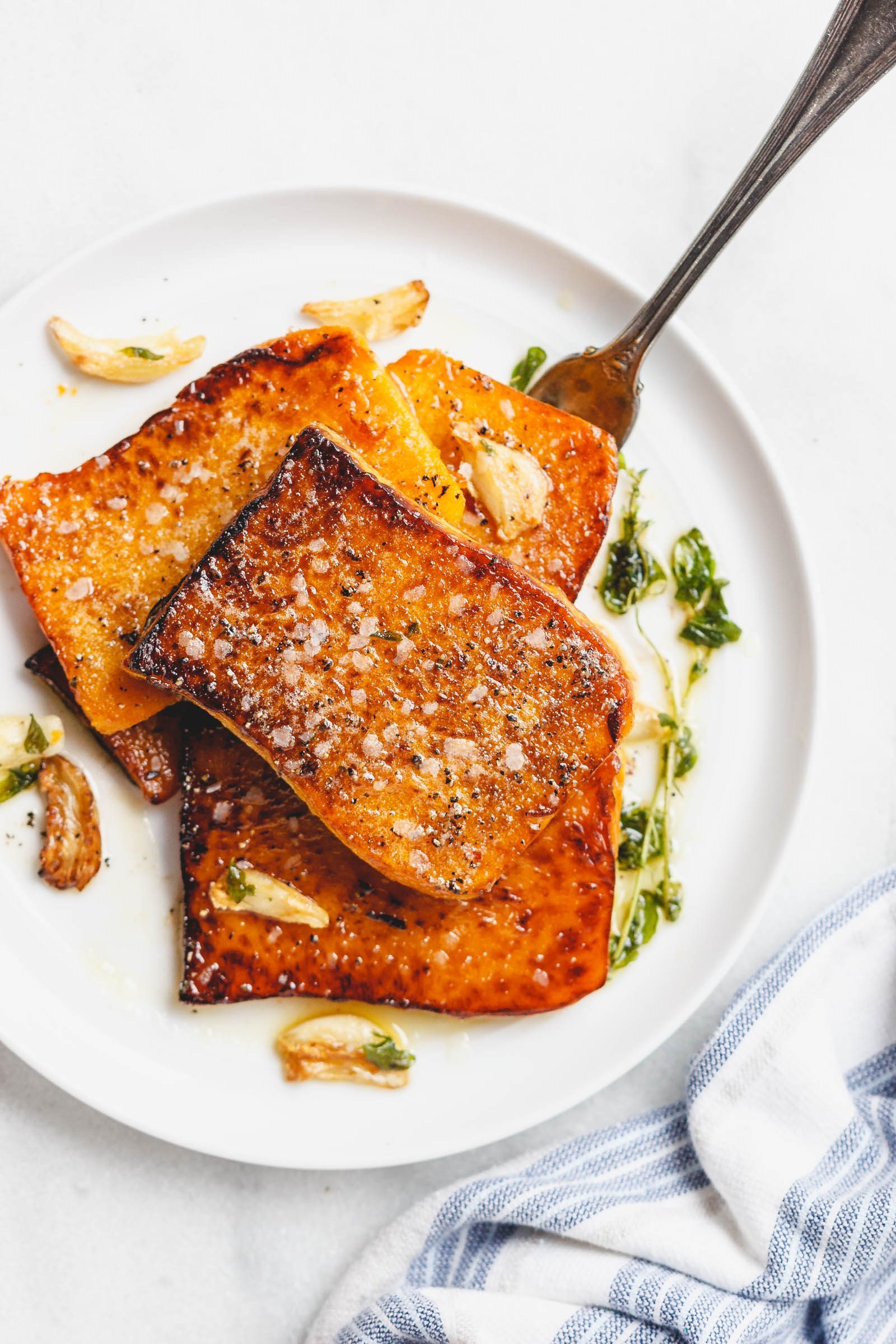 Garlic Butter Butternut Squash Steaks - Melt-in-your-mouth tender and packed with flavor! A super easy and delicious side dish for the holidays.