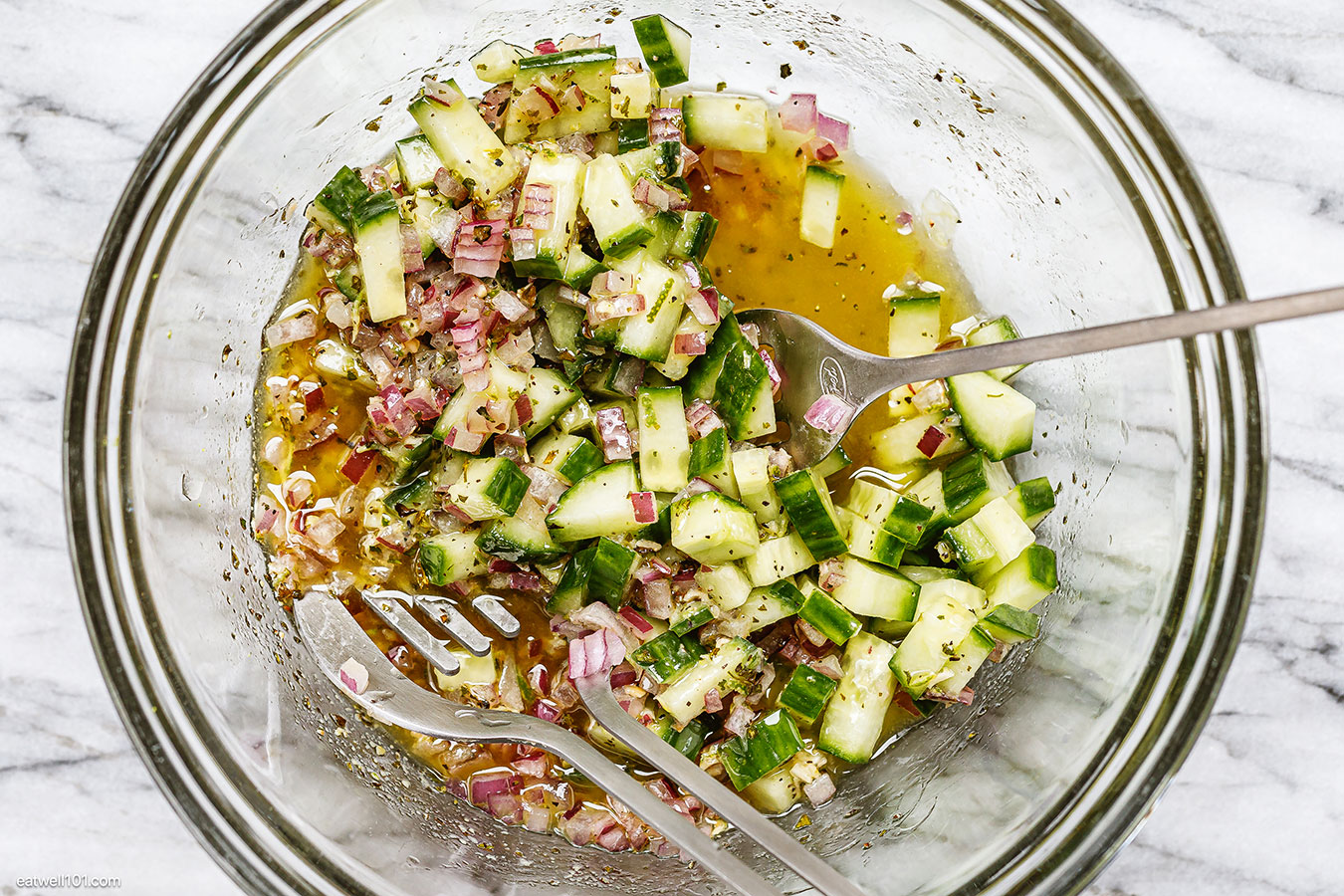 tossing cucumber and red onion salad