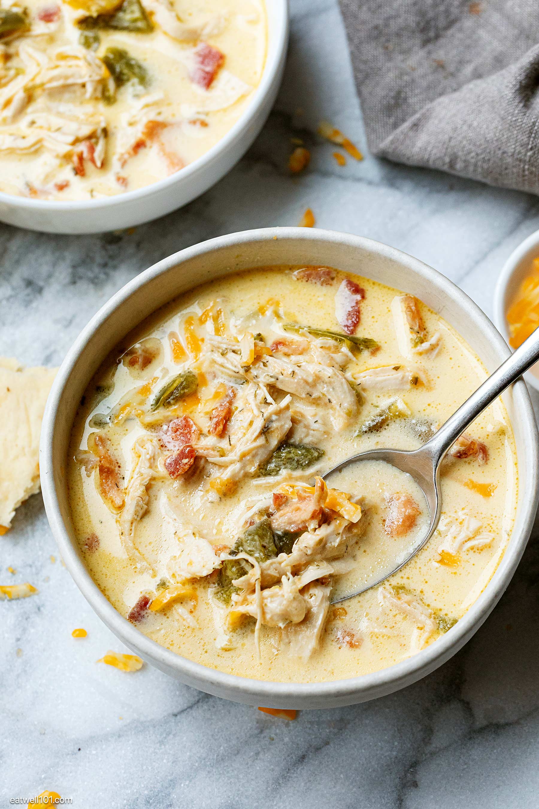 bowl of jalapeno popper chicken soup cooked in a crockpot